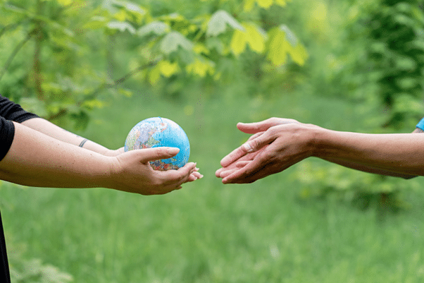 Two people exchanging a globe to illustrate sustainable development.