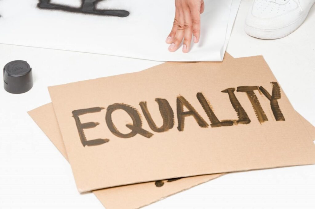 A cardboard sign with “equity” written on it to represent the social pillar
